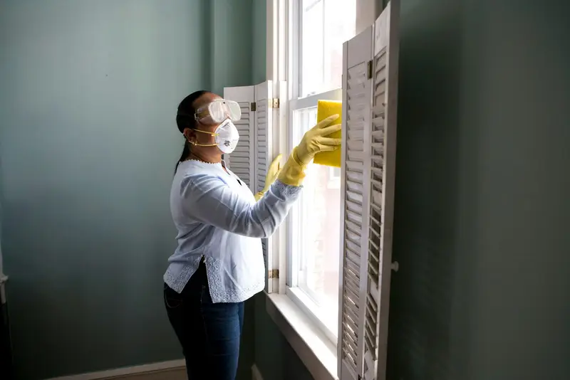 Painter preparing a window frame and wall